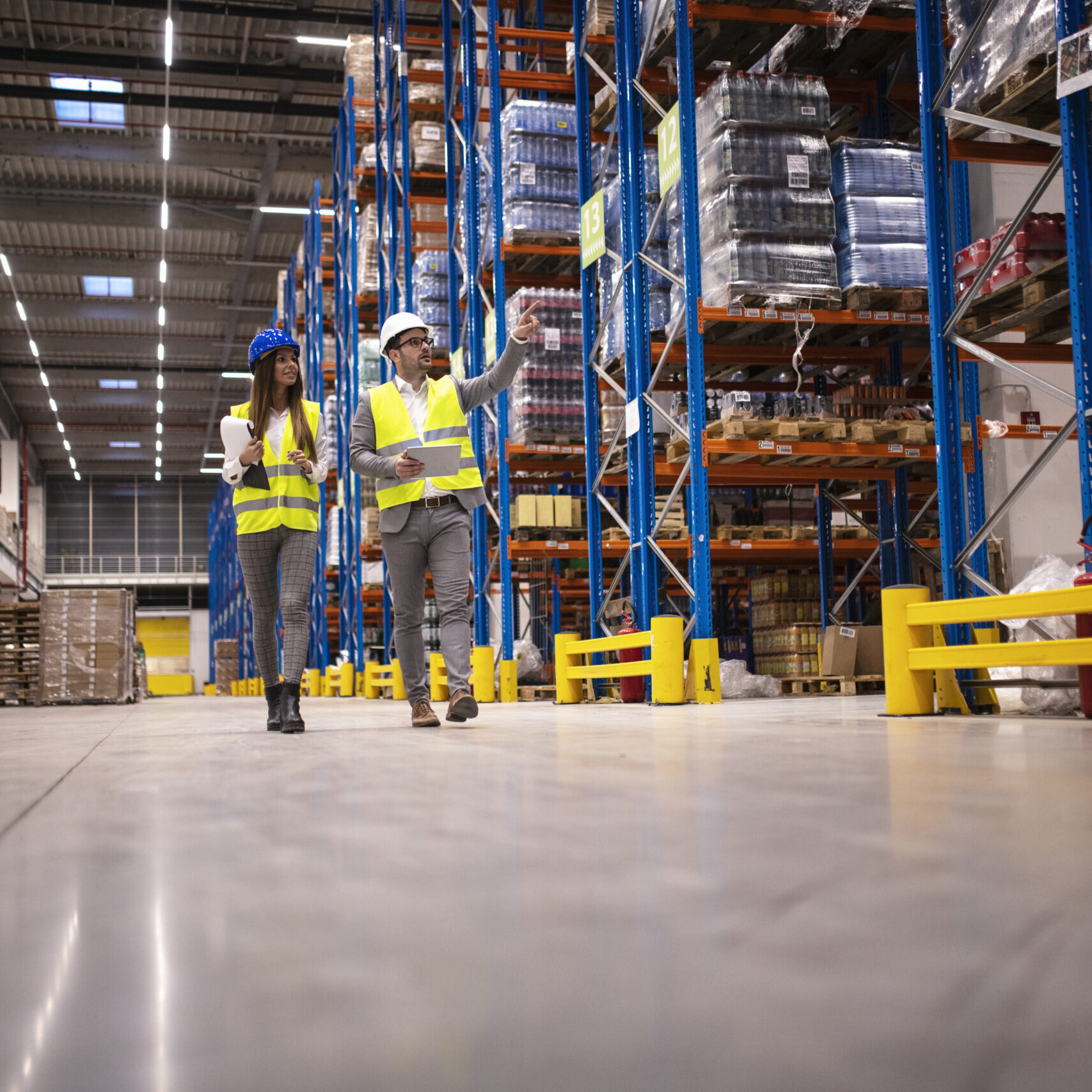 Warehouse managers walking in a large storage department controlling distribution to the market.